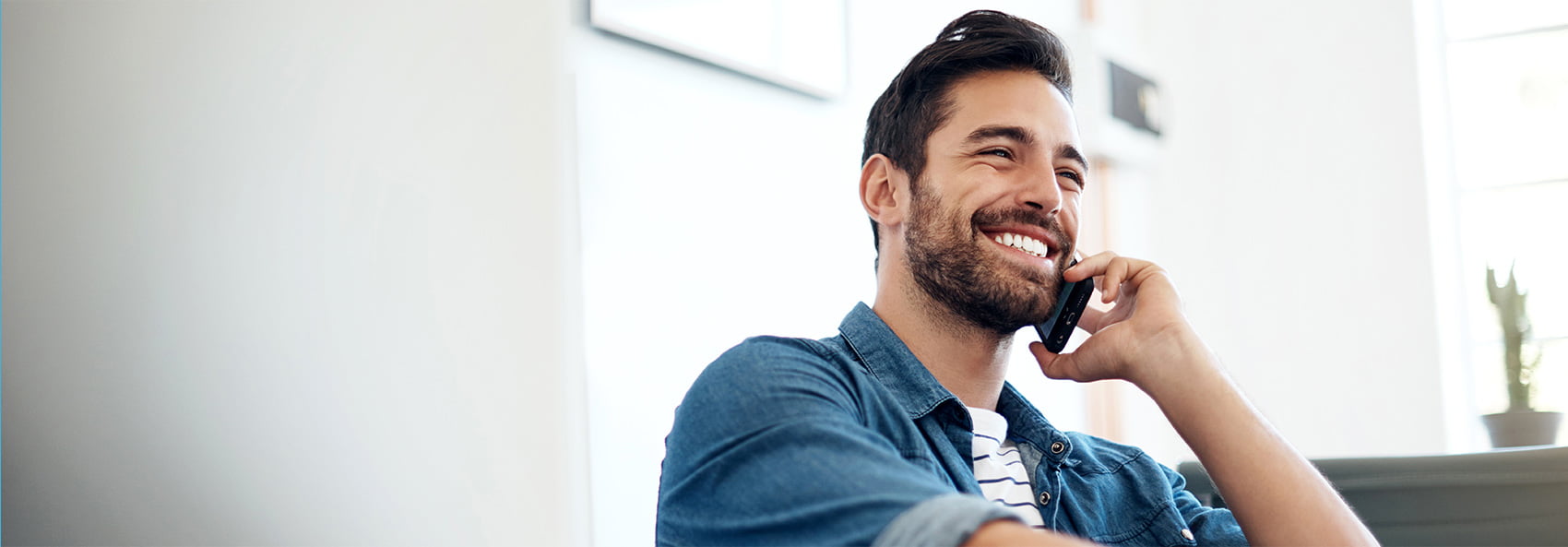 man with beard talking on phone smiling