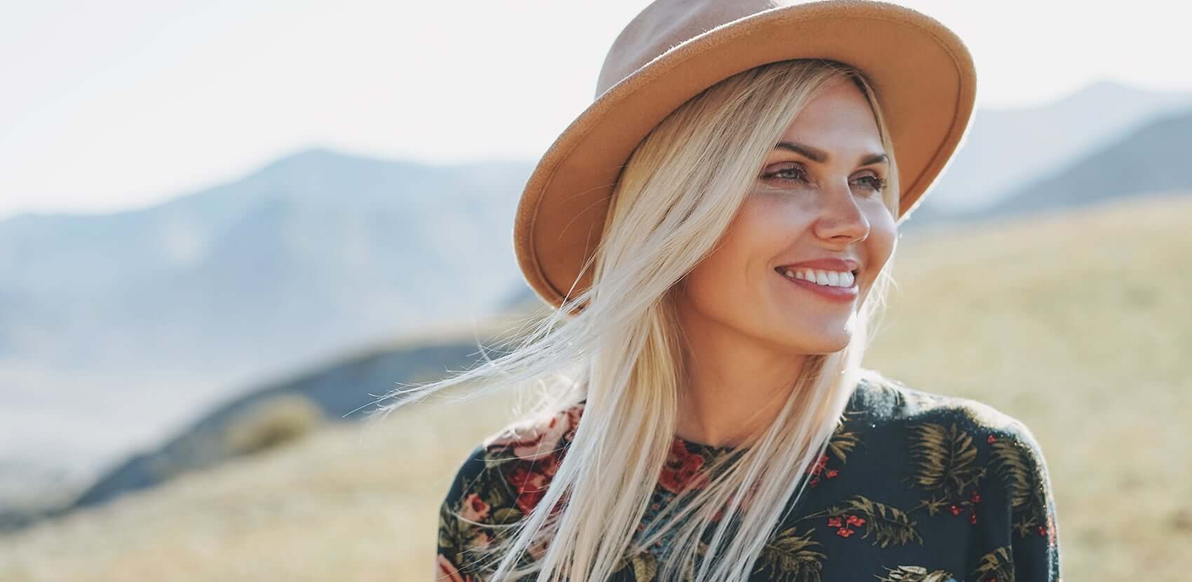 blonde woman smiling on hillside
