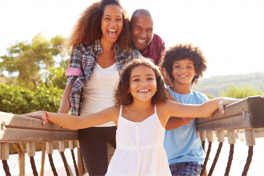 A mom and dad smile with their two children in hermitage