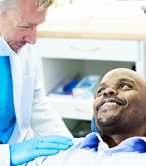 man being comforted by his dentist