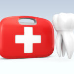 A first aid kit next to a floating white tooth to indicate a dental emergency