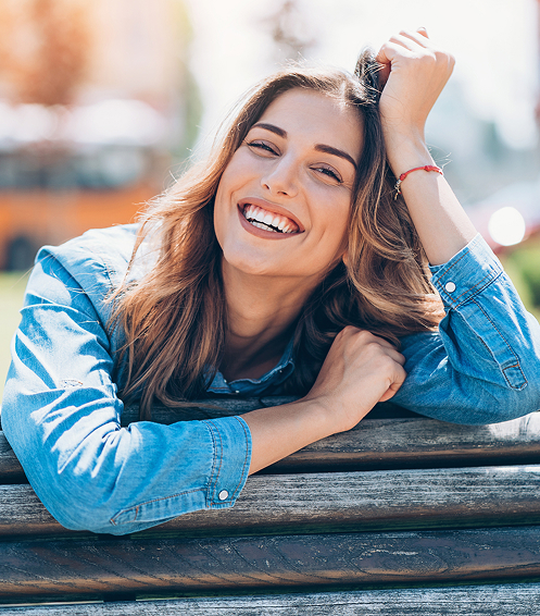 smiling woman leaning on fence