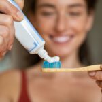 Woman using desensitizing toothpaste