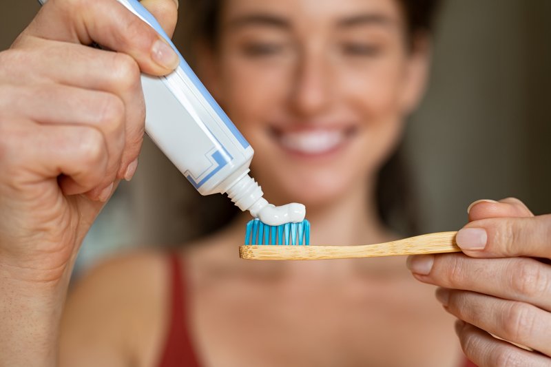 Woman using desensitizing toothpaste